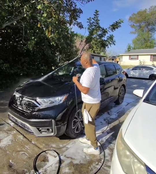 Bashir foaming and rinsing the SUV with a pressure washer